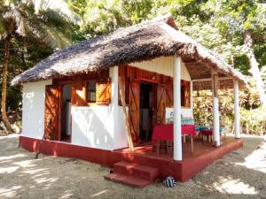 a small house with a thatched roof at Bungalow Ambanivolo in Sainte Marie +3 photos