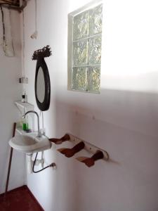 a bathroom with a sink and a mirror and a window at Bungalow Ambanivolo in Sainte Marie