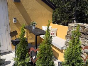 a patio with a black table and some plants at Chalet Al bosco incantato in Trieste