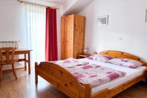 a bedroom with a wooden bed and a table at Pivka Na Meji Resort in Pivka