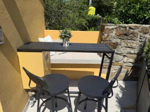 a black table and two chairs on a patio at Chalet Al bosco incantato in Trieste