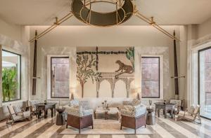 a living room with a couch and chairs and a chandelier at JW Marriott Ranthambore Resort & Spa in Sawāi Mādhopur