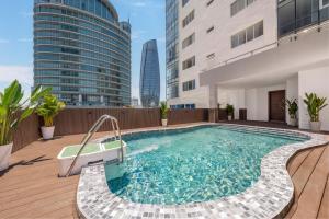 a swimming pool on the roof of a building with tall buildings at Petro Hotel Da Nang in Danang