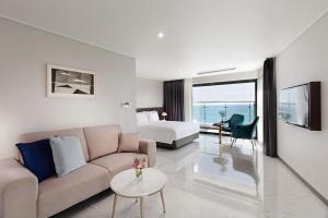 a living room with a couch and a bed at Busan Yeongmu Parade Hotel Haeundae Beach in Busan