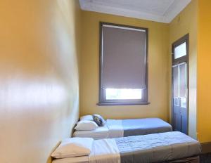 two beds in a room with a window at Cessnock Hotel Hunter Valley in Cessnock +20 photos