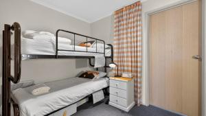a small room with two bunk beds and a dresser at Freedom in Dinner Plain