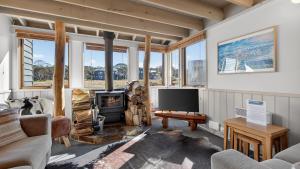 a living room with a fireplace and a tv at Freedom in Dinner Plain