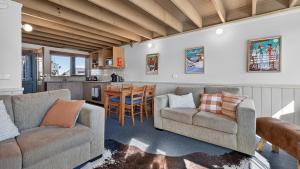 a living room with two couches and a table at Freedom in Dinner Plain