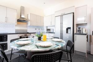 a kitchen with a table and chairs in a kitchen at 5 Bedroom House in Ashton-under-lyne with Free Parking and Easy Access to City Centre in Stalybridge