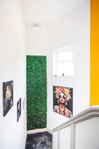 a room with a green wall with a painting of a woman at 5 Bedroom House in Ashton-under-lyne with Free Parking and Easy Access to City Centre in Stalybridge