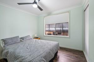 a bedroom with a bed and a window at Tranquility Place in Evans Head