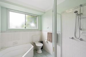 a white bathroom with a toilet and a shower at Tranquility Place in Evans Head +10 photos