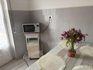 a kitchen with a table with a vase of purple flowers at I Tulipani in Genoa