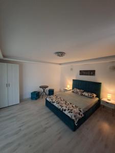 a bedroom with a large bed and two tables in it at Casa Bon Relax , Rooms&Apartaments in Tuzla