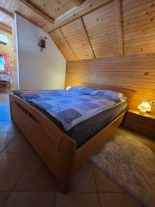 a bed in a room with a wooden ceiling at Apartments & Chalet Jurček in Luče
