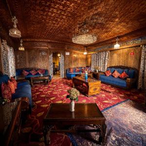a living room with blue couches and a table at Heritage Amina Group Of Houseboats in Srinagar