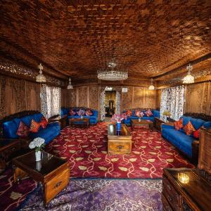 a living room with blue couches and a red carpet at Heritage Amina Group Of Houseboats in Srinagar