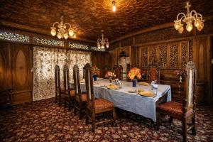 a dining room with a long table and chairs at Heritage Amina Group Of Houseboats in Srinagar +34 photos