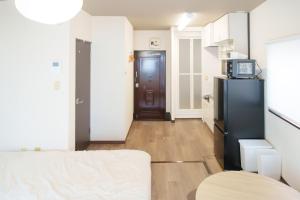 a living room with a black refrigerator and a kitchen at Bears Building in Kumamoto