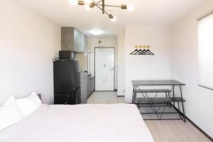 a bedroom with a white bed and a table at Bears Building in Kumamoto