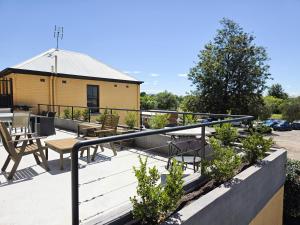 a patio with tables and chairs and a building at Cessnock Hotel Hunter Valley in Cessnock