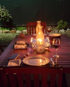a table with a plate of food and a glass of wine at Unpretentious peaceful Cottage in Clanwilliam