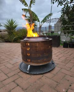 a fire pit on a brick patio with flames at Unpretentious peaceful Cottage in Clanwilliam