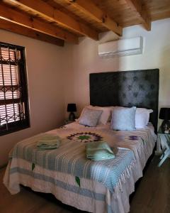 a bedroom with a large bed with two pillows on it at Unpretentious peaceful Cottage in Clanwilliam +35 photos