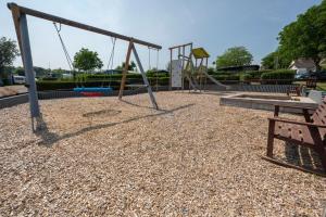 an empty playground with swings and a bench at Camping Seewiese in Pfedelbach