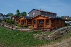 a large wooden house on a hill with a fence at Camping Seewiese in Pfedelbach