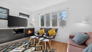 a living room with a couch and a fireplace at Humffray 3 in Dinner Plain