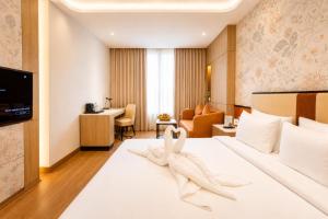a hotel room with a bed with a towel on it at Pride Premier Greater Noida in Noida