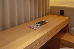 a electronic device sitting on top of a wooden table at H Avenue Hotel Gwangju Cheomdan in Gwangju