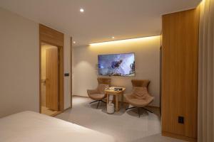 a hotel room with a bed and two chairs and a table at H Avenue Hotel Gwangju Cheomdan in Gwangju