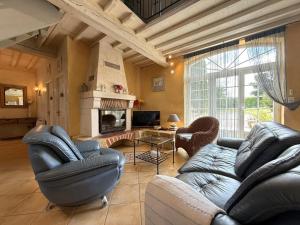 ein Wohnzimmer mit Ledermöbeln und einem Kamin in der Unterkunft Lasquet in Mont-Disse