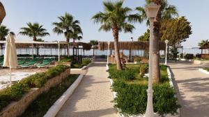 a street light next to a beach with palm trees at Maya World Didyma Hotel - Ultra All Inclusive in Didim