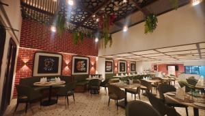 a restaurant with tables and chairs and a brick wall at Pride Premier Greater Noida in Noida