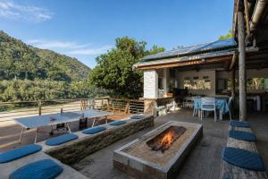 a patio with a table and a fire pit at Kaaimans River Deckhouse in Wilderness