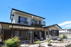 a house with large windows and a balcony at DON chan GuestHouse Nikko ,7 minutes walk from Imaichi Station in Nikko