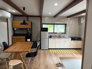 a kitchen with a table and chairs in a room at 海辺の宿なみとけ in Shodoshima