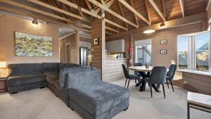 a living room with a couch and a table and chairs at Snowgums 10 in Dinner Plain