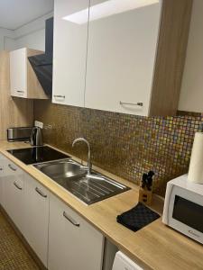 a kitchen with a sink and a microwave at Garden Apartment in Baden-Baden +38 photos