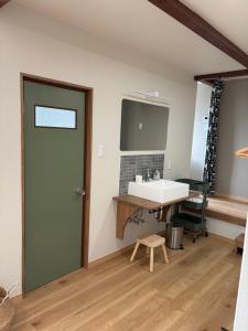 a bathroom with a sink and a desk with a mirror at 海辺の宿なみとけ in Shodoshima