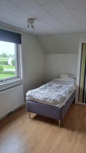 a bedroom with a bed in a room with a window at Villa Skäris in Falkenberg