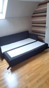 a bed in a room on a wooden floor at Villa Skäris in Falkenberg +5 photos