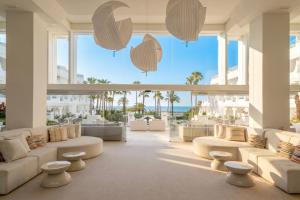 a living room with white furniture and a view of the ocean at Iberostar Selection Marbella Coral Beach in Marbella