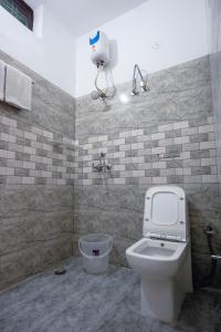 a bathroom with a toilet and a water tank at Gharonda Manor-A Home Beyond Home -Best Luxury Budget Stay Near ISBT in Dehradun