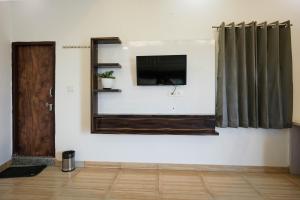 a room with a tv and a mirror on a wall at Gharonda Manor-A Home Beyond Home -Best Luxury Budget Stay Near ISBT in Dehradun +27 photos