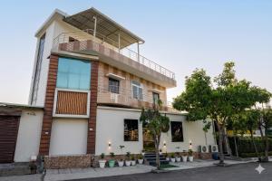 a building with a balcony on top of it at Gharonda Manor-A Home Beyond Home -Best Luxury Budget Stay Near ISBT in Dehradun