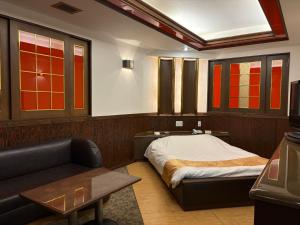 a room with a bed and a couch and a table at HotelG7 in Tokyo